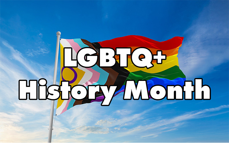 Progress Pride flag waving against a blue sky with the words “LGBTQ+ History Month.”