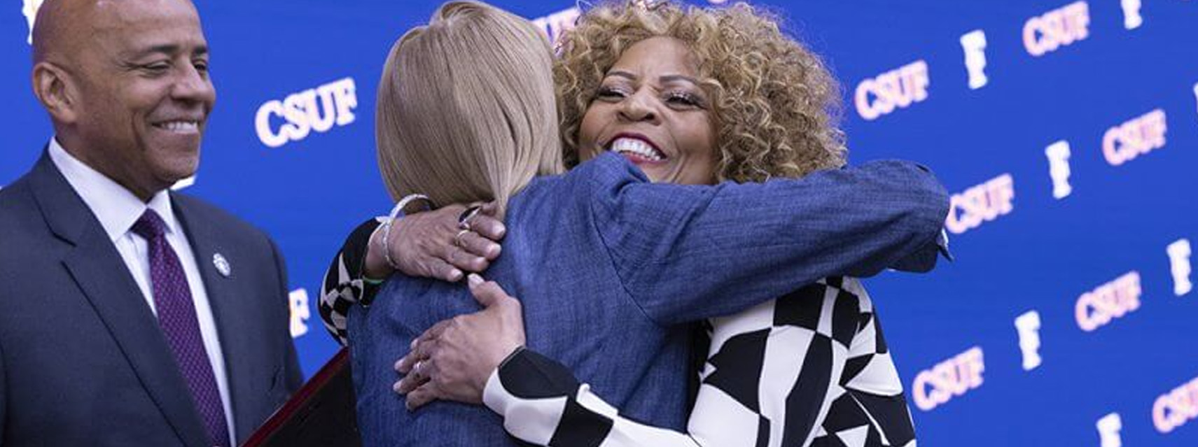 2 CSUF employees hugging each other at the University Awards program