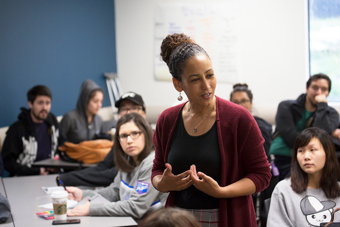 woman standing and talking in a classroom to students