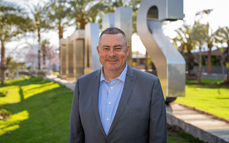 Dave Edwards, ASI executive director, in front of the Titan letters. 