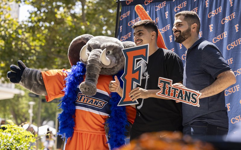 Tuffy with two people holding an "F" and "Titans" logos