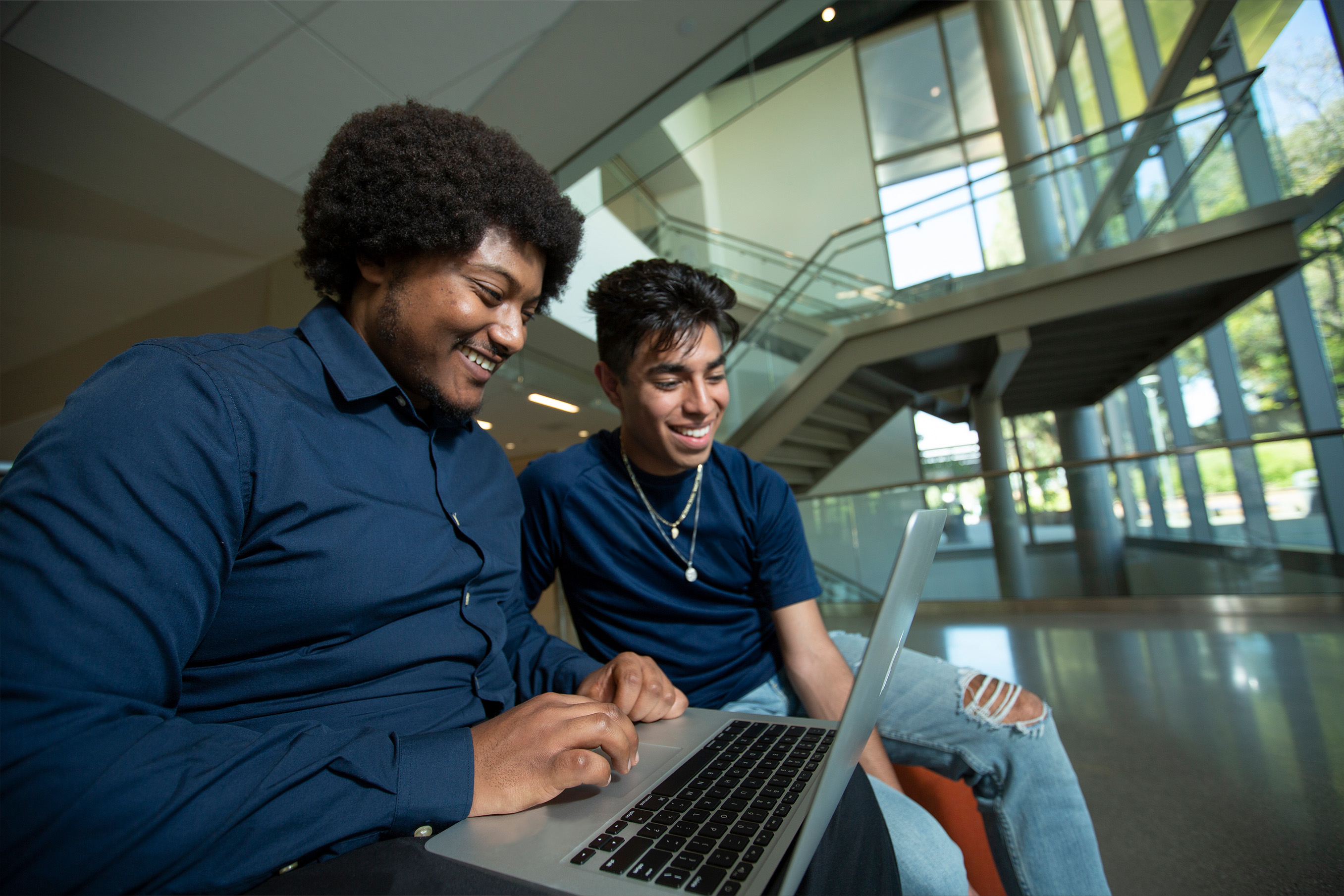 two students looking at a laptop