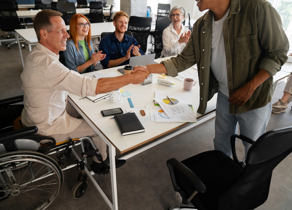 a man in a wheelchair shaking hands with a man standing