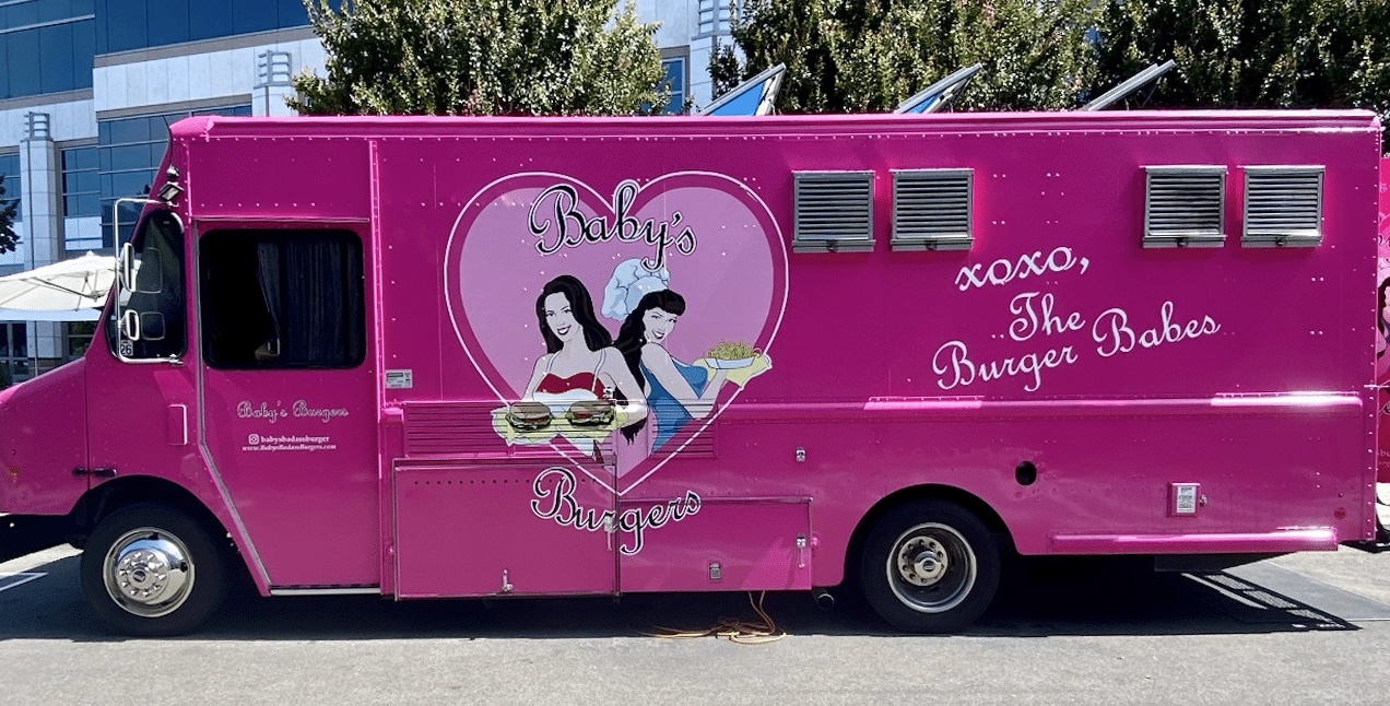 Baby's Burger pink food truck with a big hears encircling two food servers.