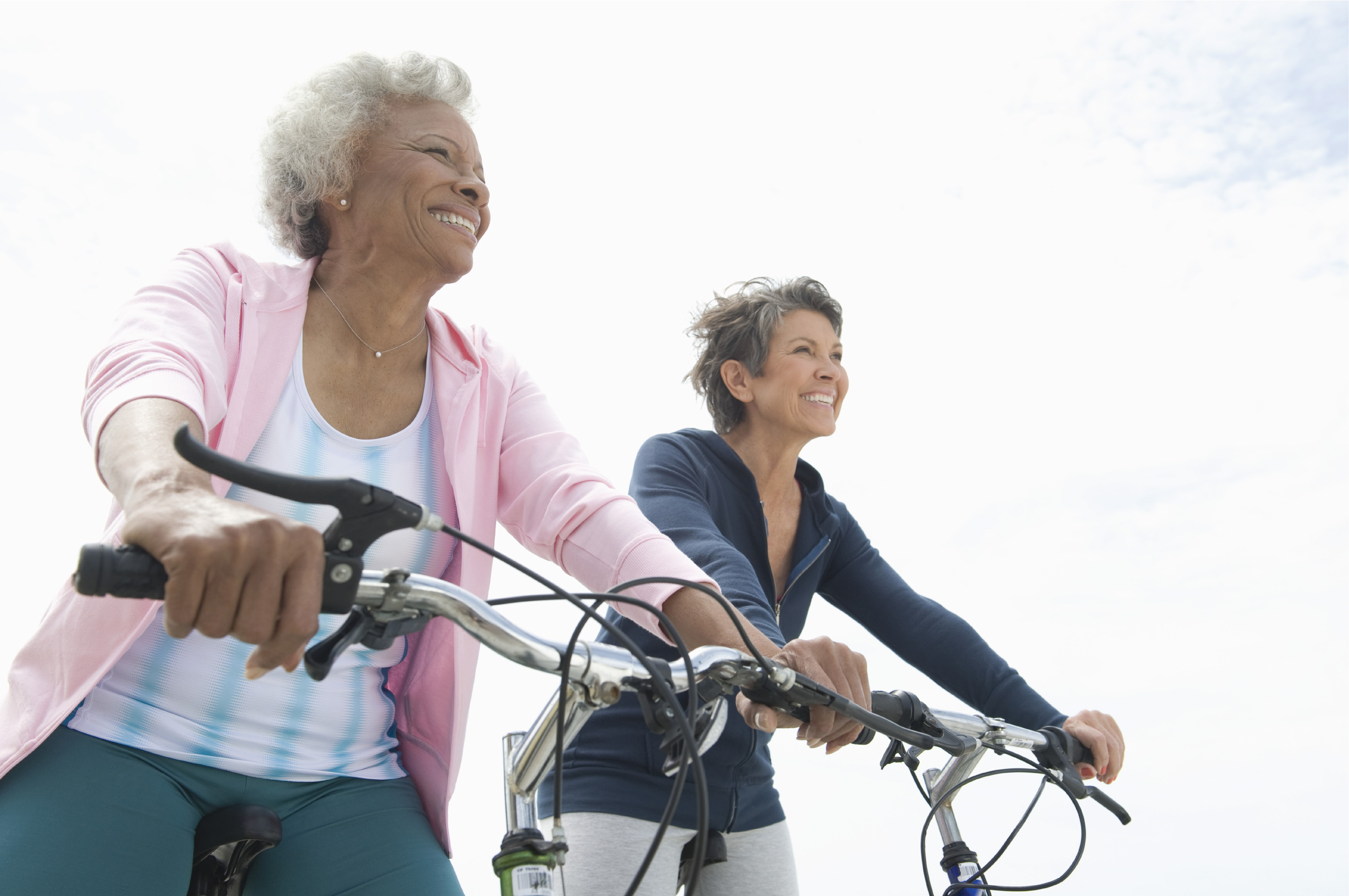 2 older ladies biking and smiling