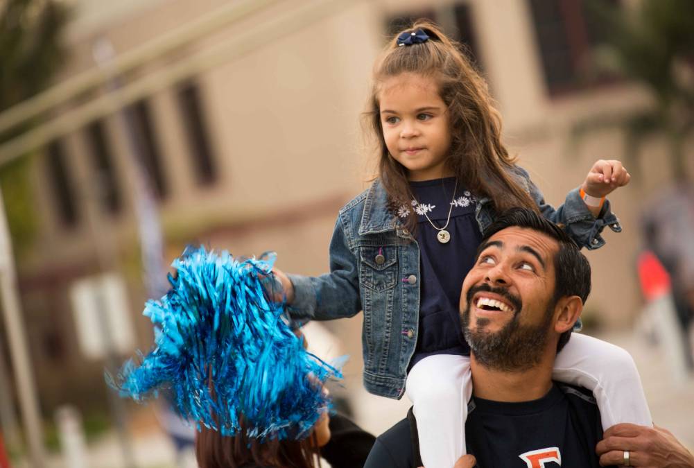 a daughter sitting on her father's shoulders