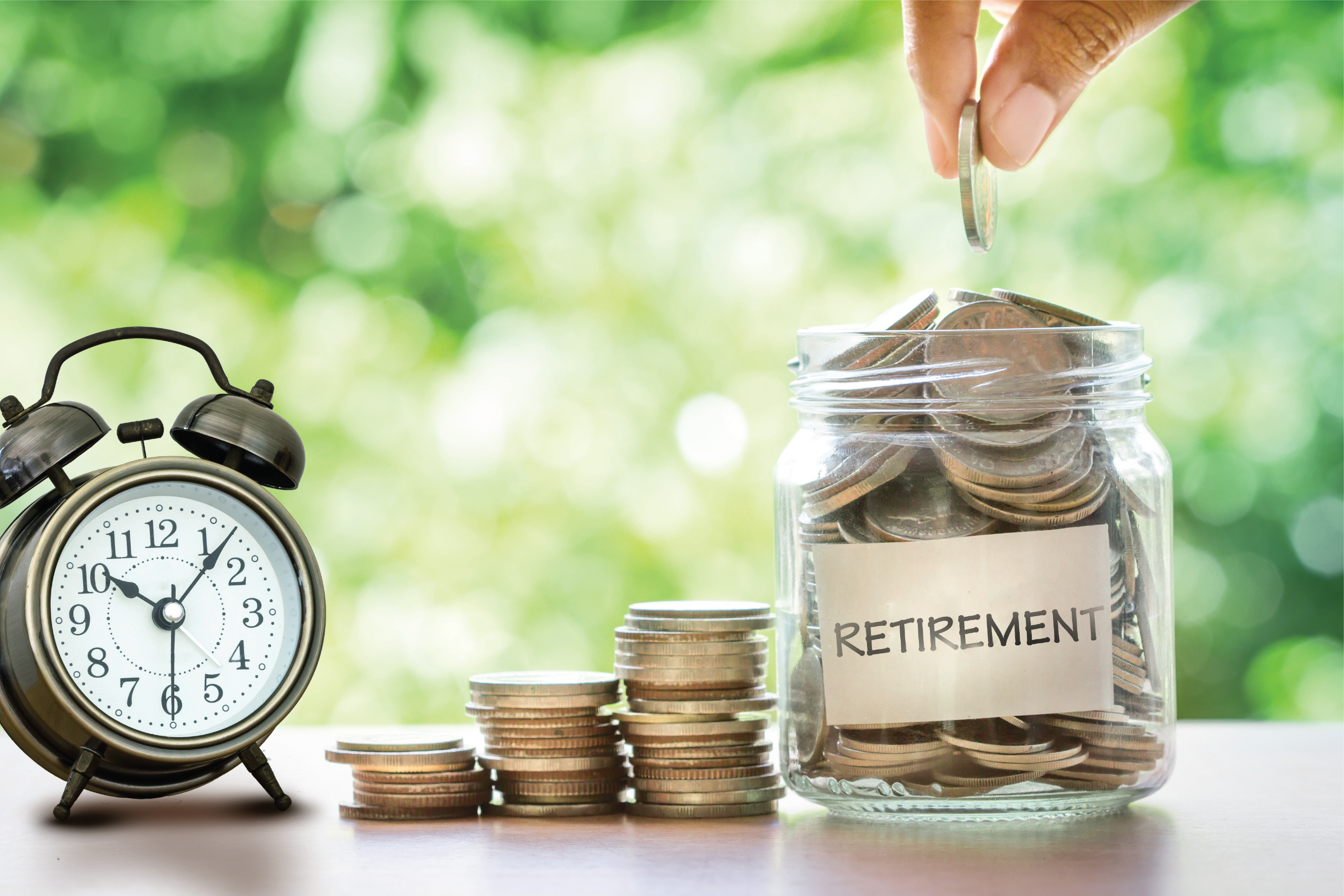 a hand putting a coin into a jar with the label retirement