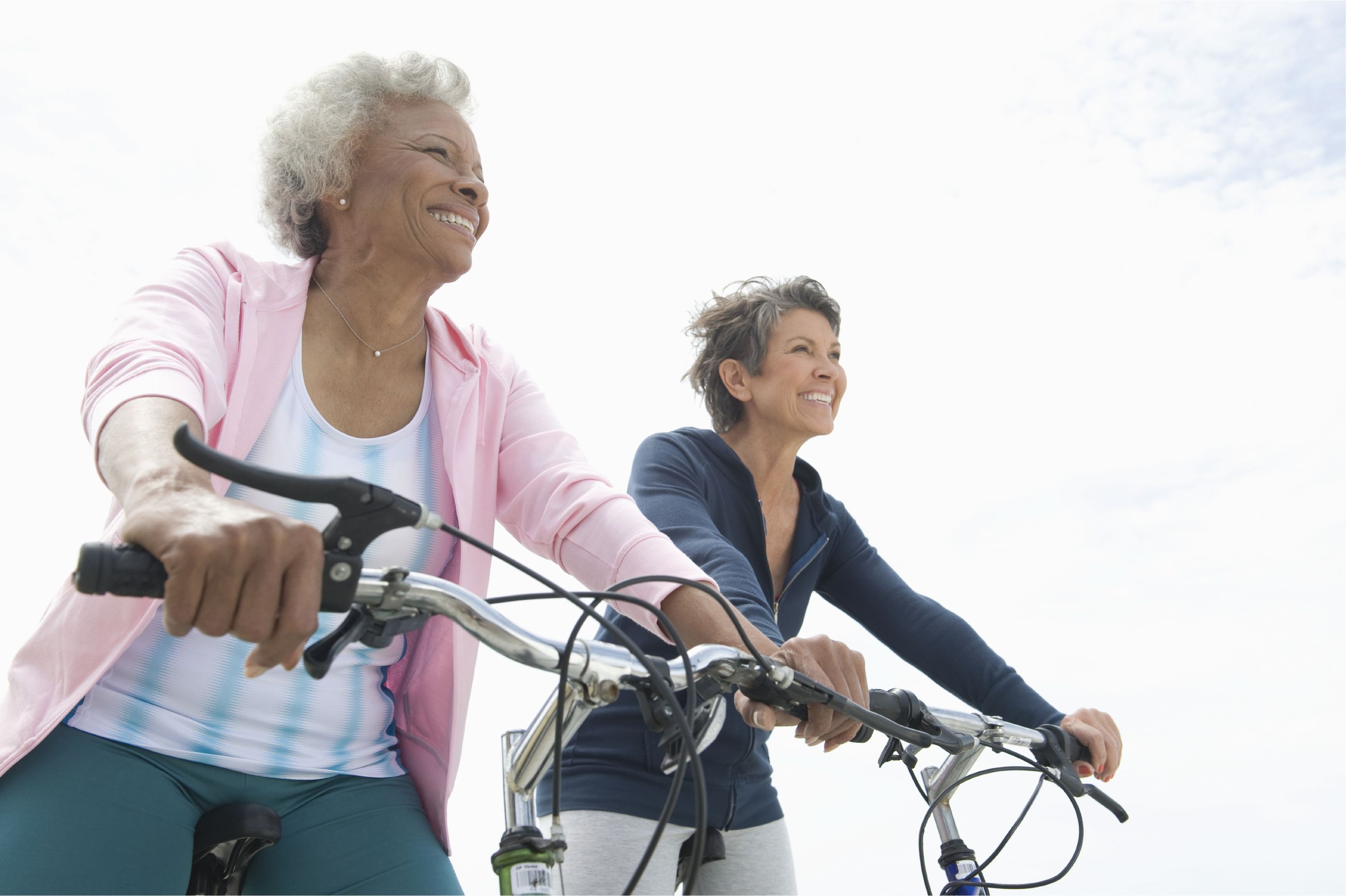 2 older ladies biking and smiling